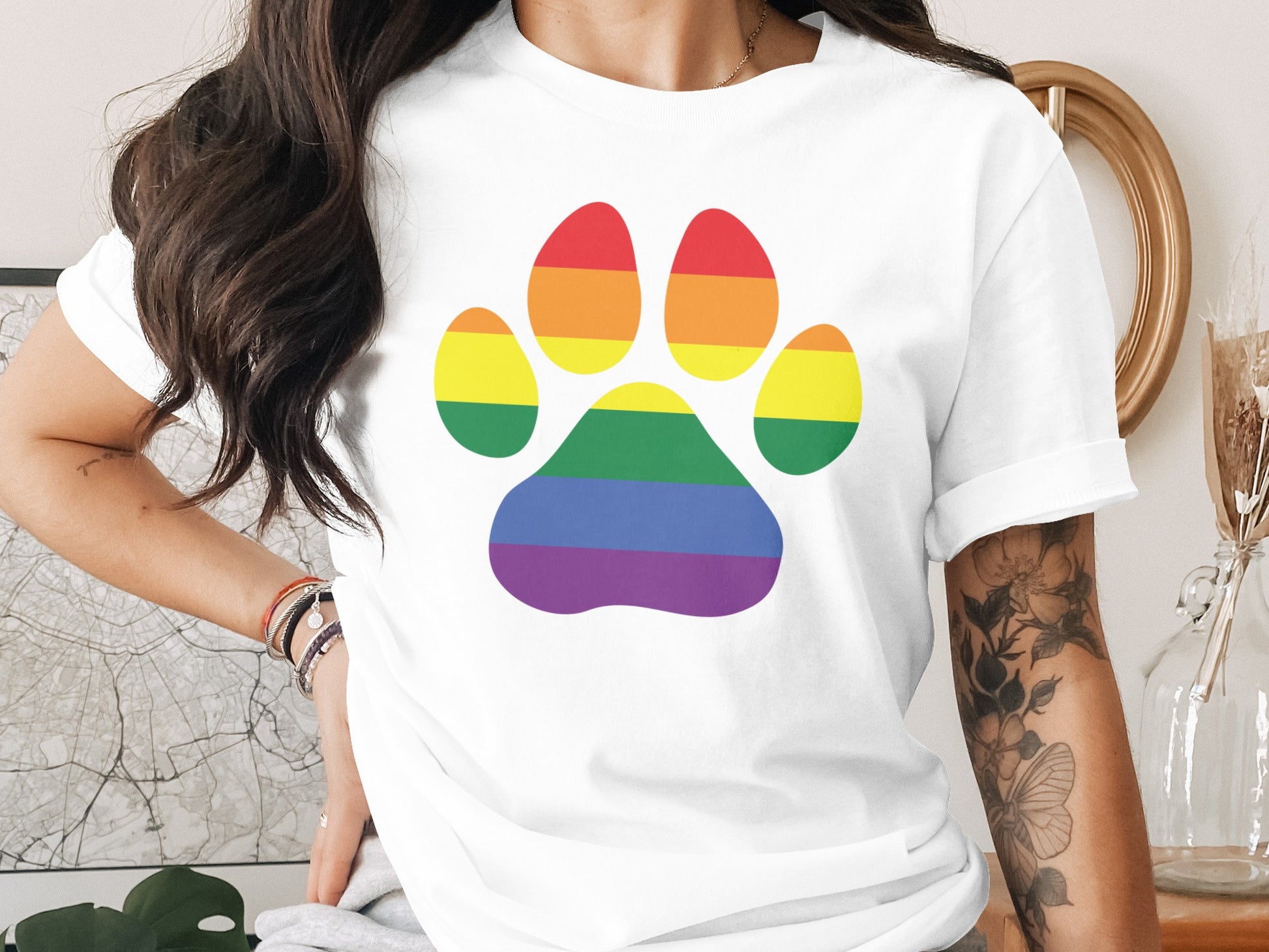 White t-shirt with a rainbow paw print design.