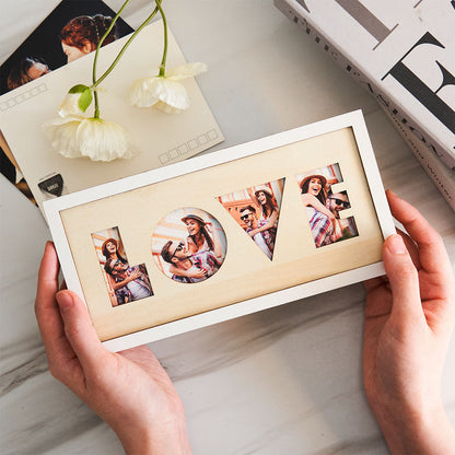 Hands holding LOVE wooden photo frame