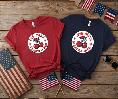 Two t-shirts, red and navy, with "Little Miss Firecracker" text and cherry graphic.