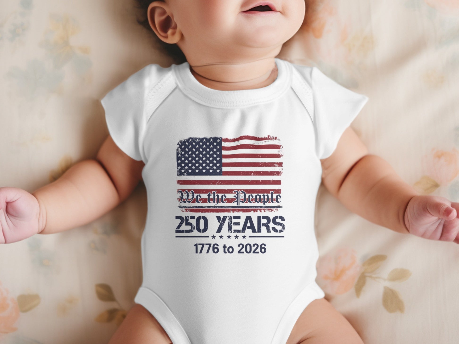Baby in white onesie with American flag and "We the People 250 Years 1776 to 2026" text.