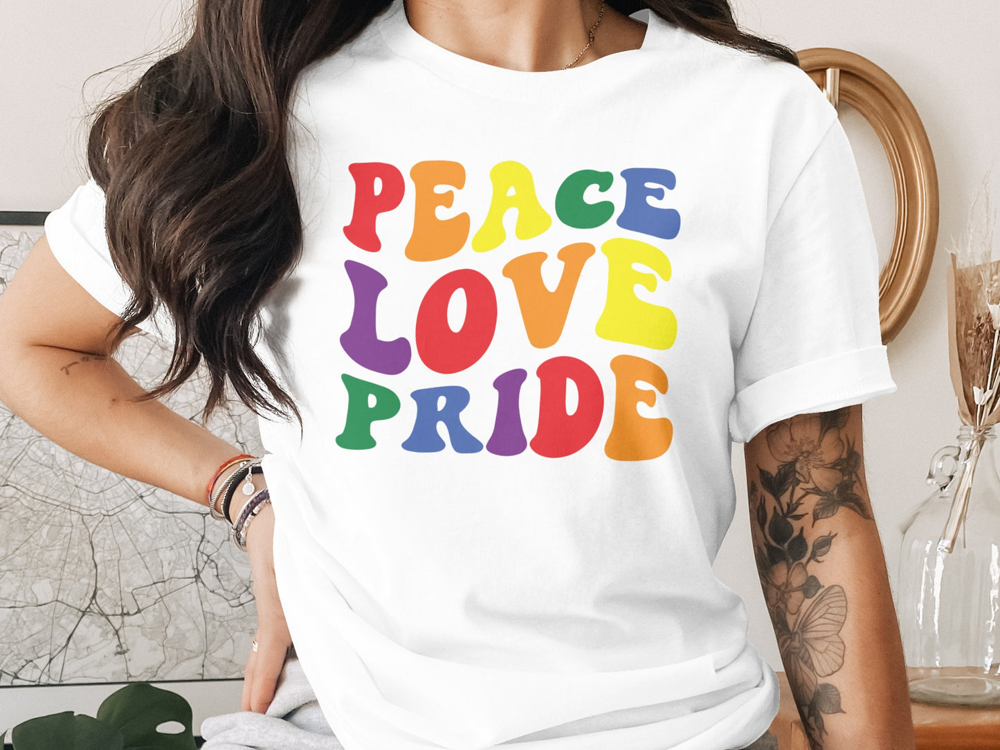 White t-shirt with "Peace Love Pride" in rainbow block letters.