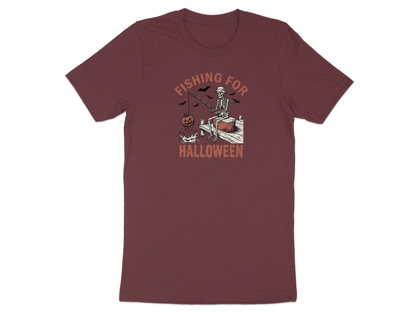 Skeleton fishing for Halloween with pumpkins and bats graphic on burgundy t-shirt.