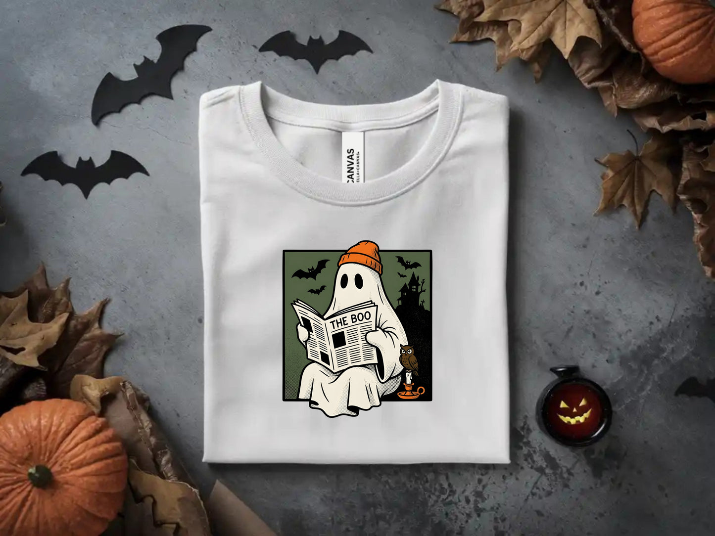 White t-shirt with a ghost reading "The Boo" newspaper against a spooky background.