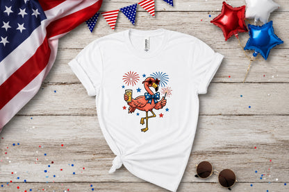 White t-shirt with a cartoon flamingo wearing sunglasses, holding fireworks.