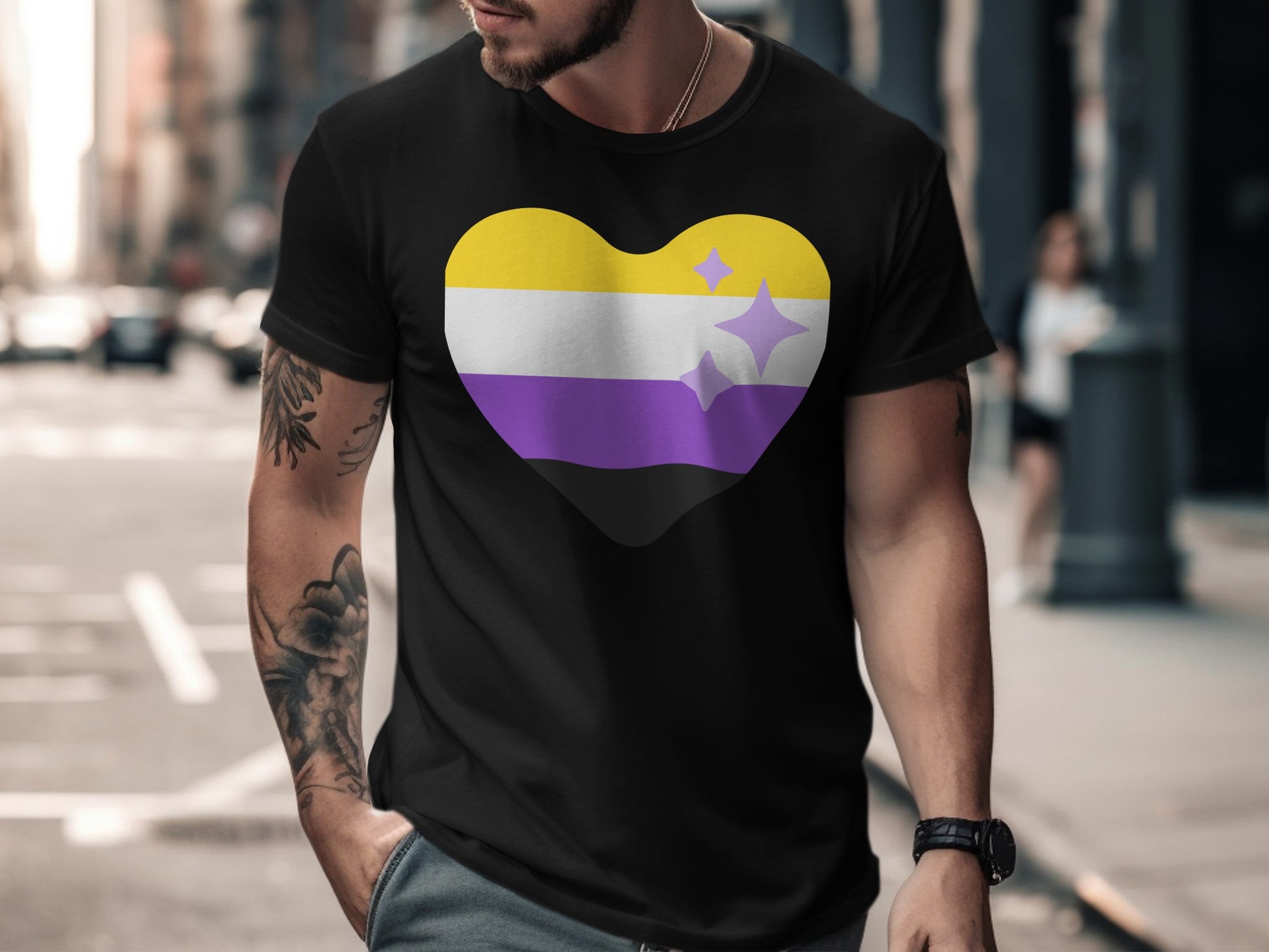 Black t-shirt with a non-binary pride heart symbol featuring yellow, white, purple stripes and purple stars.