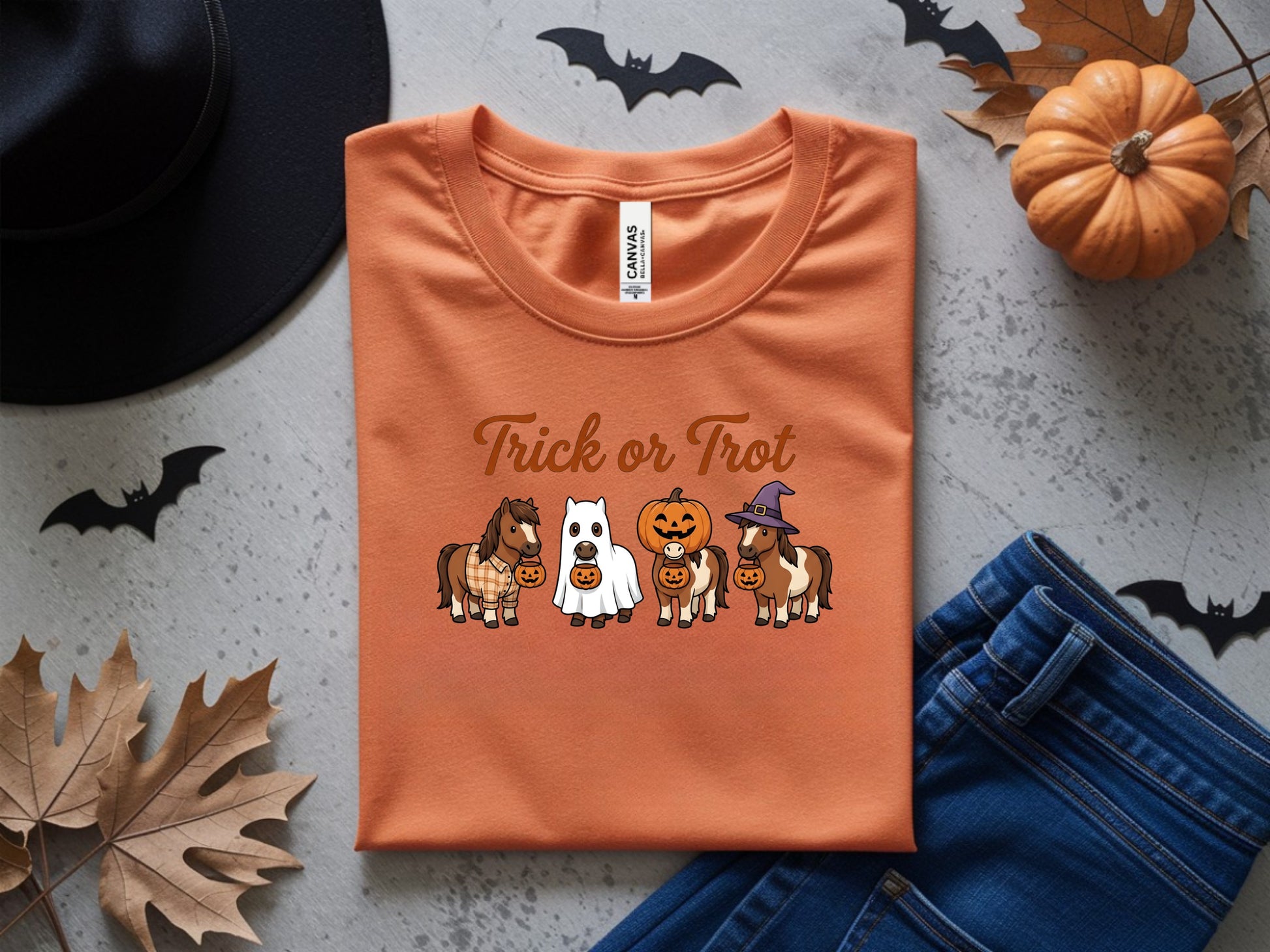 Orange t-shirt with "Trick or Trot" text and horses dressed for Halloween.