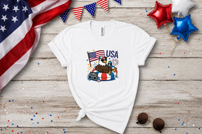 White t-shirt with eagle in swim ring, American flag, and boombox graphic.
