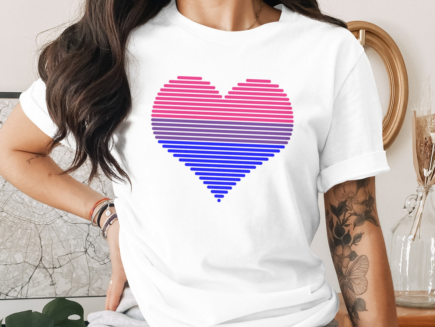White t-shirt with a pink, purple, and blue striped heart graphic.