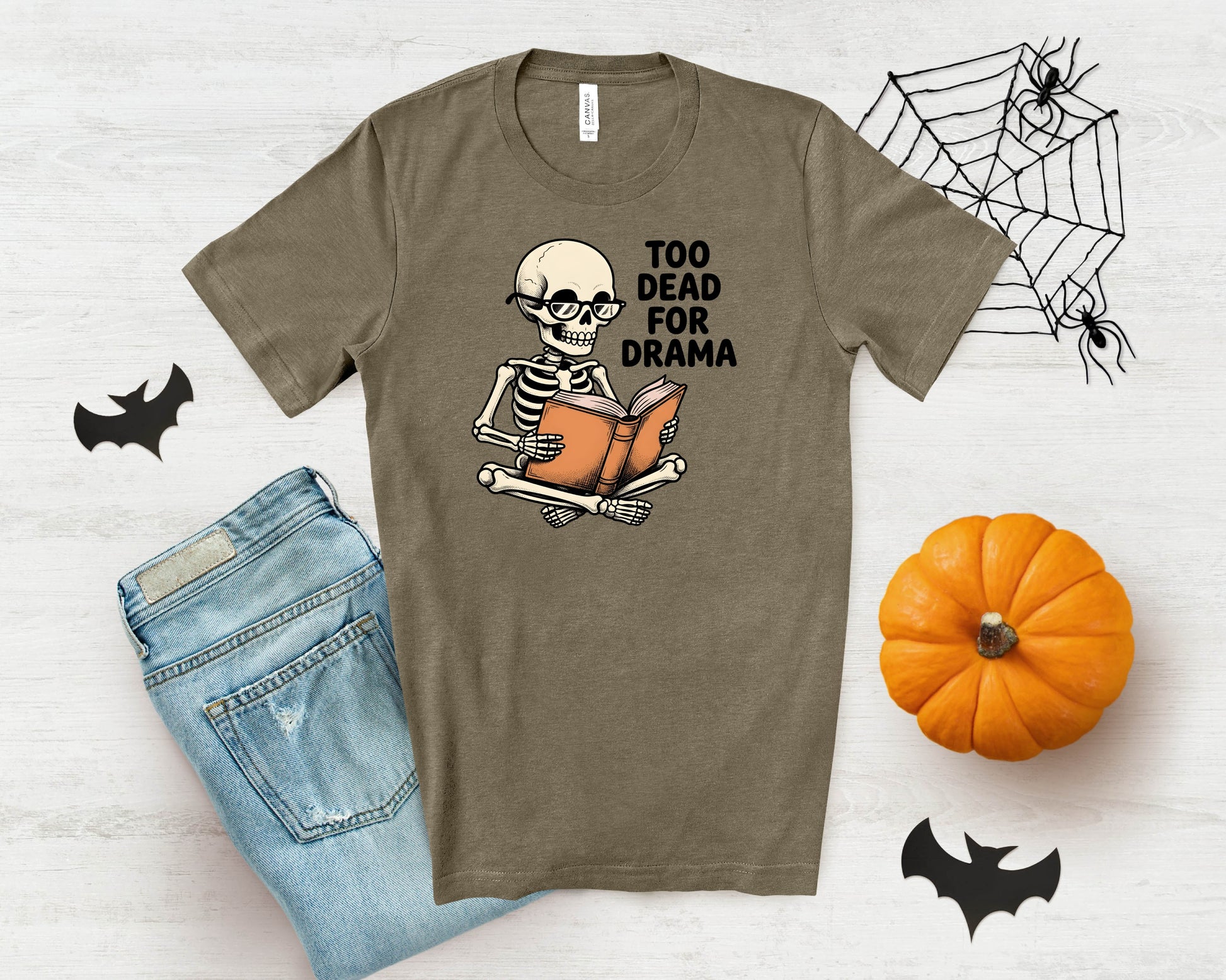 Skeleton wearing glasses reading a book with text "TOO DEAD FOR DRAMA".