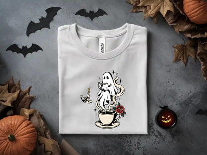 White t-shirt with ghost reading by a steaming cup of coffee and a rose.