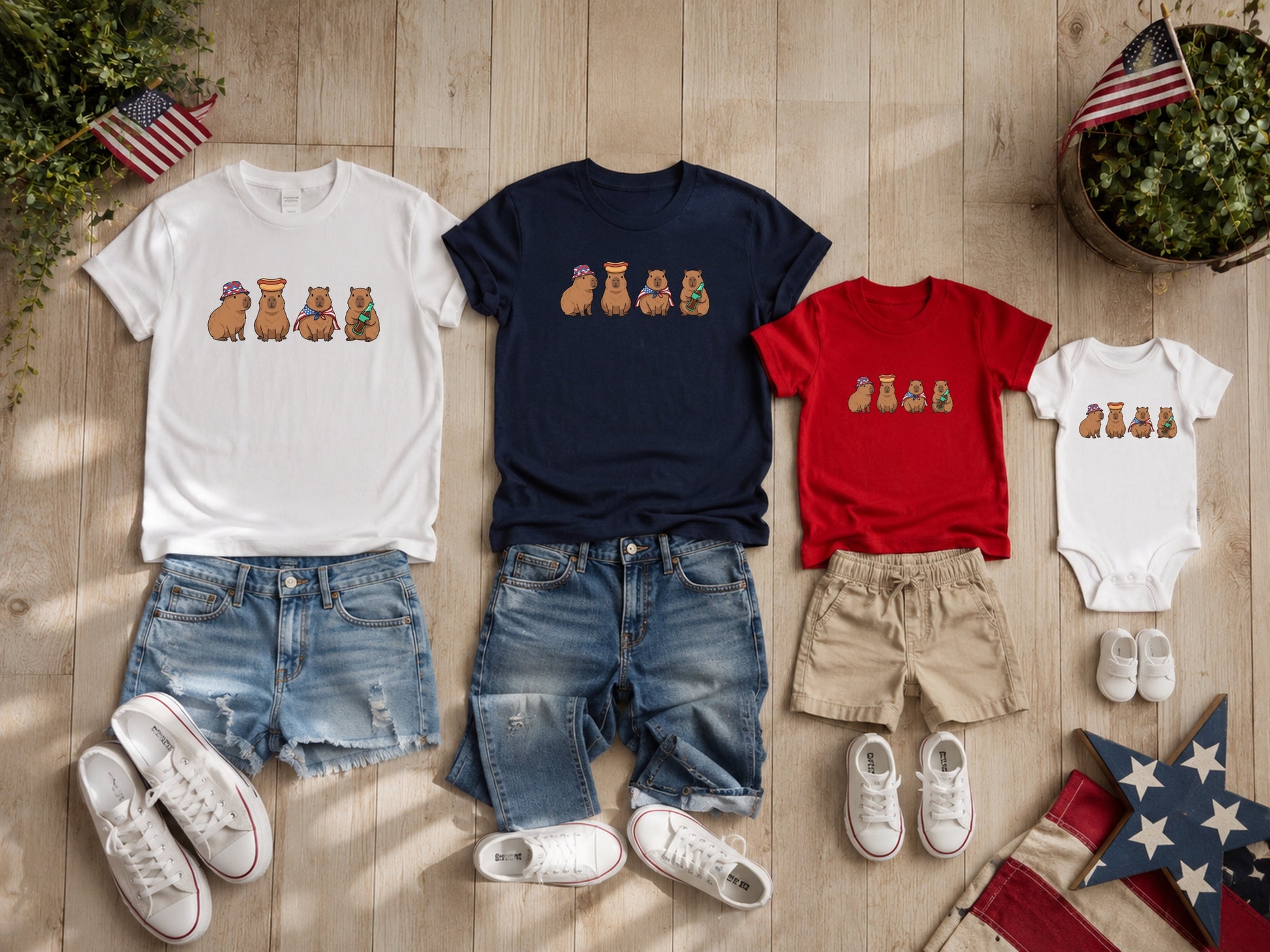 Capybaras wearing festive hats on white, navy, and red t-shirts and onesie.
