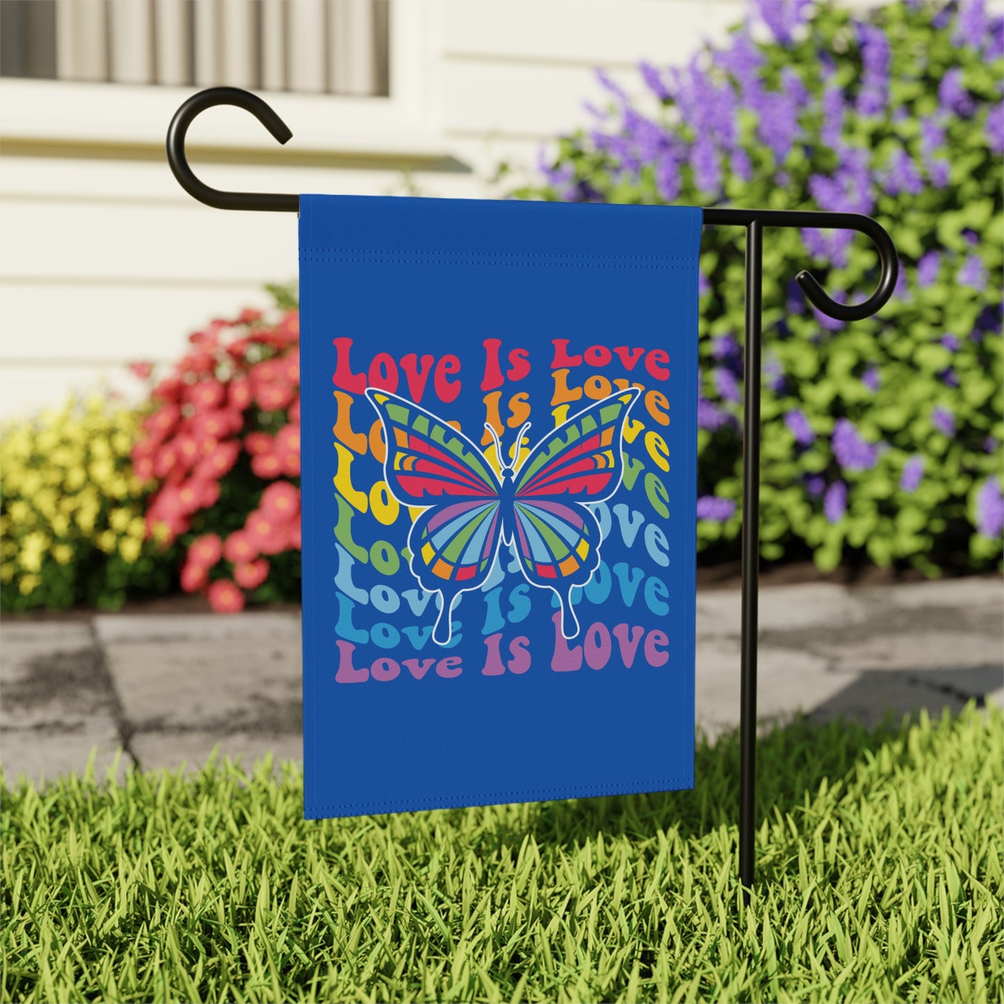 Blue garden flag with rainbow butterfly and "Love Is Love" text.