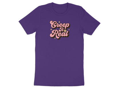 Purple t-shirt with "Creep It Real" text in pink and brown groovy font.