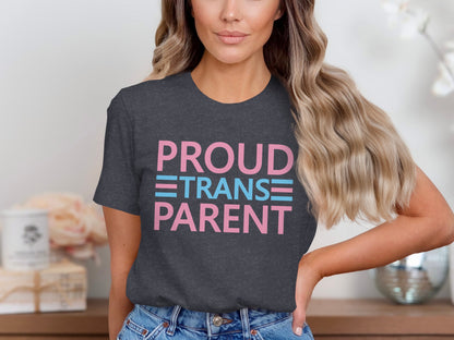 Dark t-shirt with "PROUD TRANS PARENT" in pink and blue lettering.
