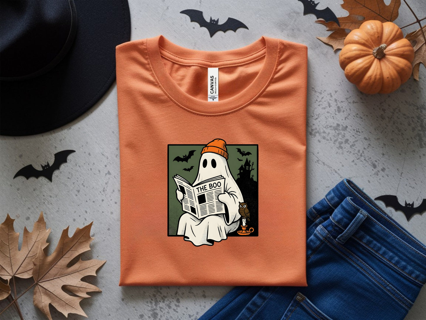 Orange t-shirt with a graphic of a ghost reading a newspaper titled "The Boo".