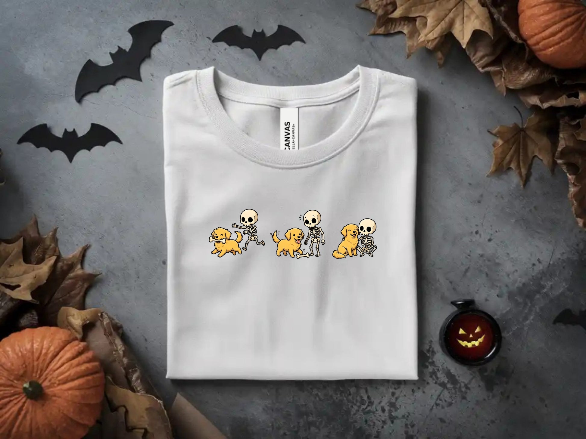 White t-shirt with cartoon skeletons playing with golden retrievers graphic.
