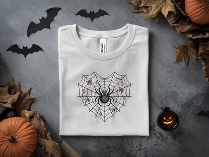White t-shirt with a black spider on a web with pink bows and drops.