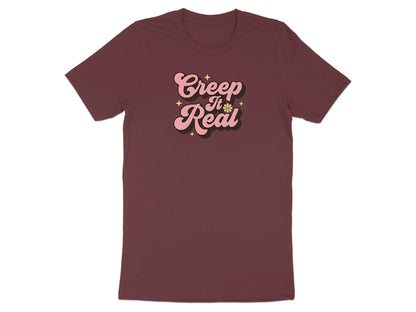 Maroon t-shirt with pink "Creep It Real" text and star graphics.