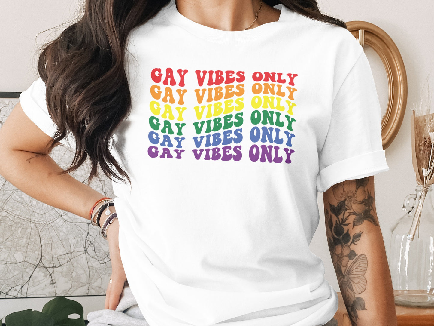 White t-shirt with "GAY VIBES ONLY" repeated in rainbow colors.
