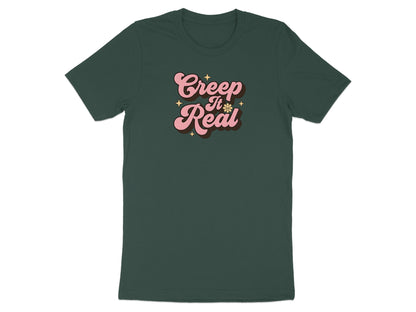 Dark green t-shirt with pink "Creep It Real" text and star design.