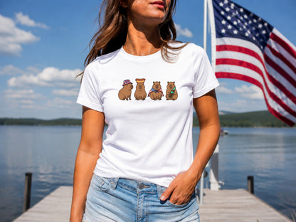 White t-shirt with four cartoon capybaras wearing hats and holding flags.
