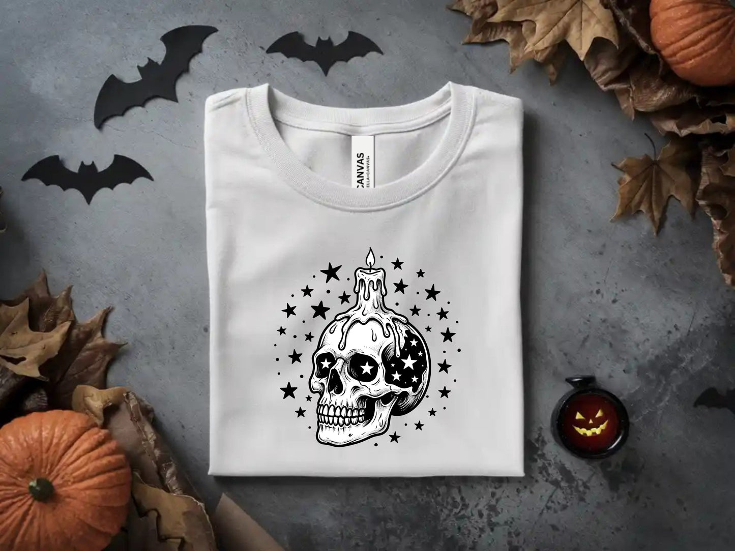 White t-shirt with a black skull and candle design surrounded by stars