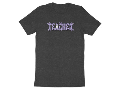 Dark t-shirt with the word "TEACHER" in purple, decorated with Halloween motifs.