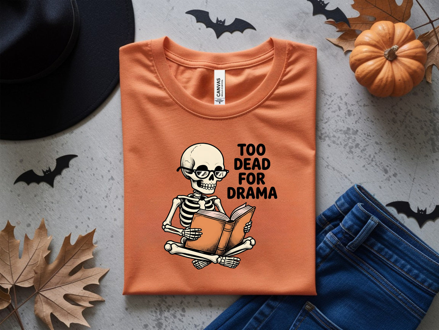 Orange t-shirt with skeleton reading a book and "TOO DEAD FOR DRAMA" text.