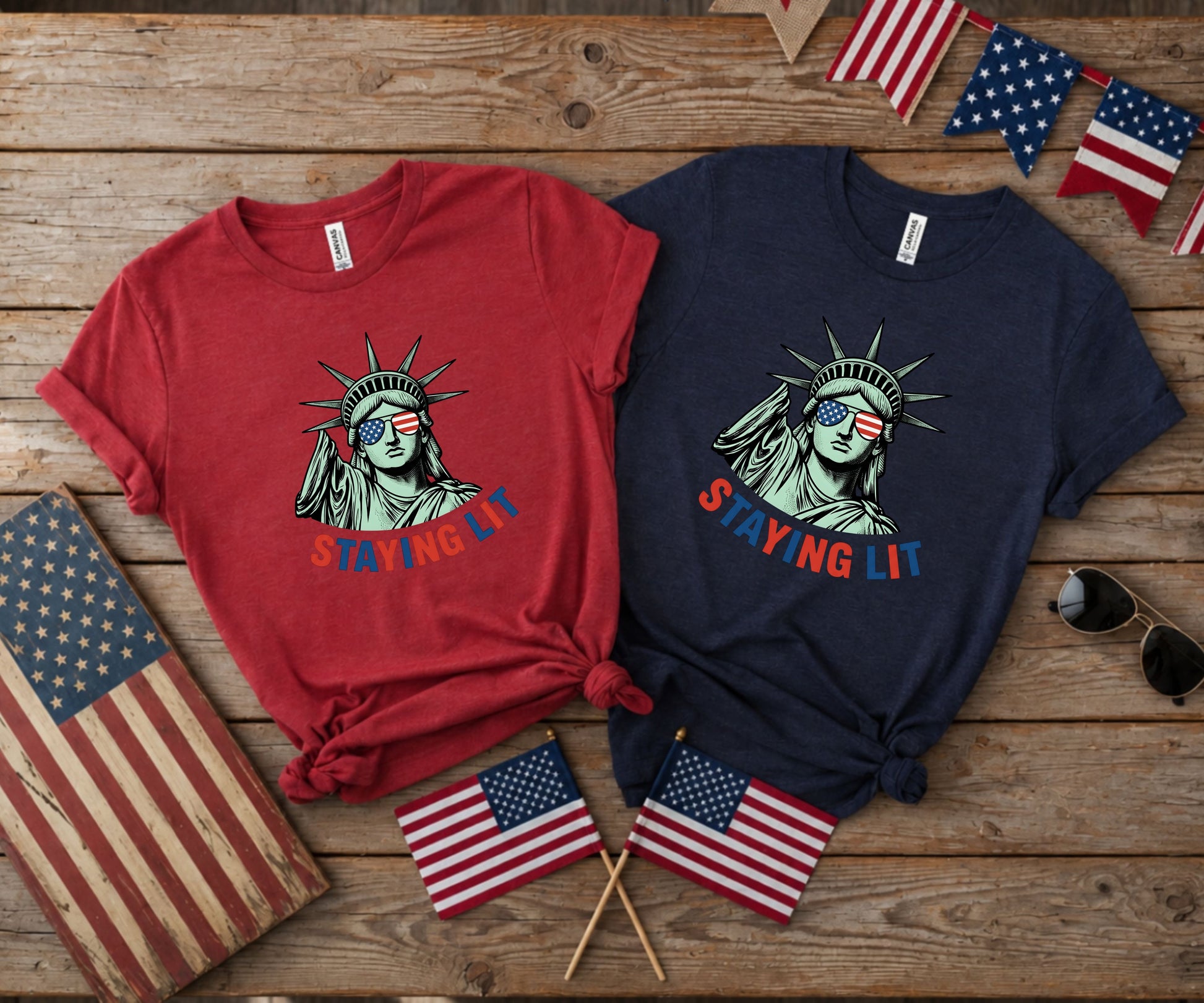 Red and navy t-shirts with Statue of Liberty graphic and "STAYING LIT" text.