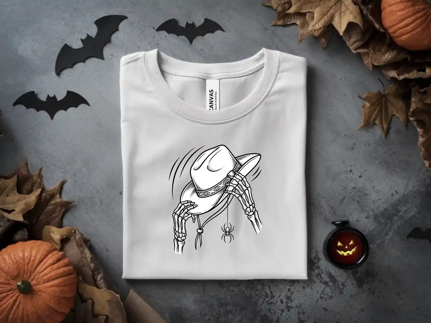 White t-shirt with a skeleton hand holding a cowboy hat and a spider.