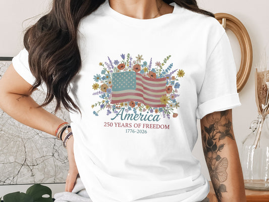 White t-shirt with floral American flag and text "America 1776-2026".