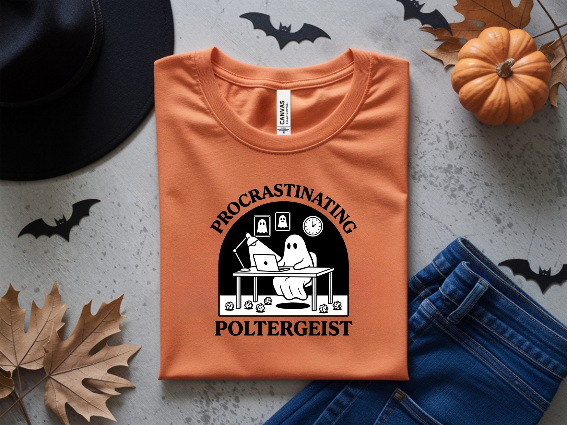 Orange t-shirt with "Procrastinating Poltergeist" graphic featuring a ghost at a desk.