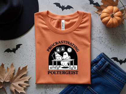Orange t-shirt with "Procrastinating Poltergeist" graphic featuring a ghost at a desk.