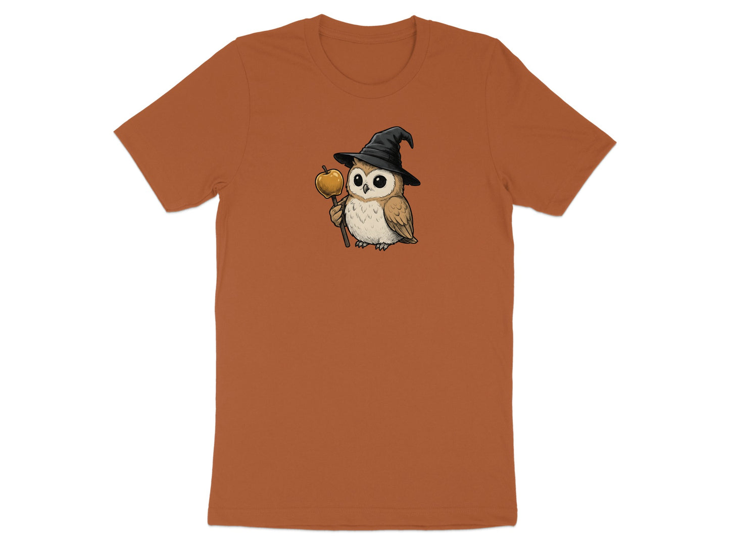 Brown t-shirt with a cartoon owl wearing a witch hat holding a golden apple on a stick.