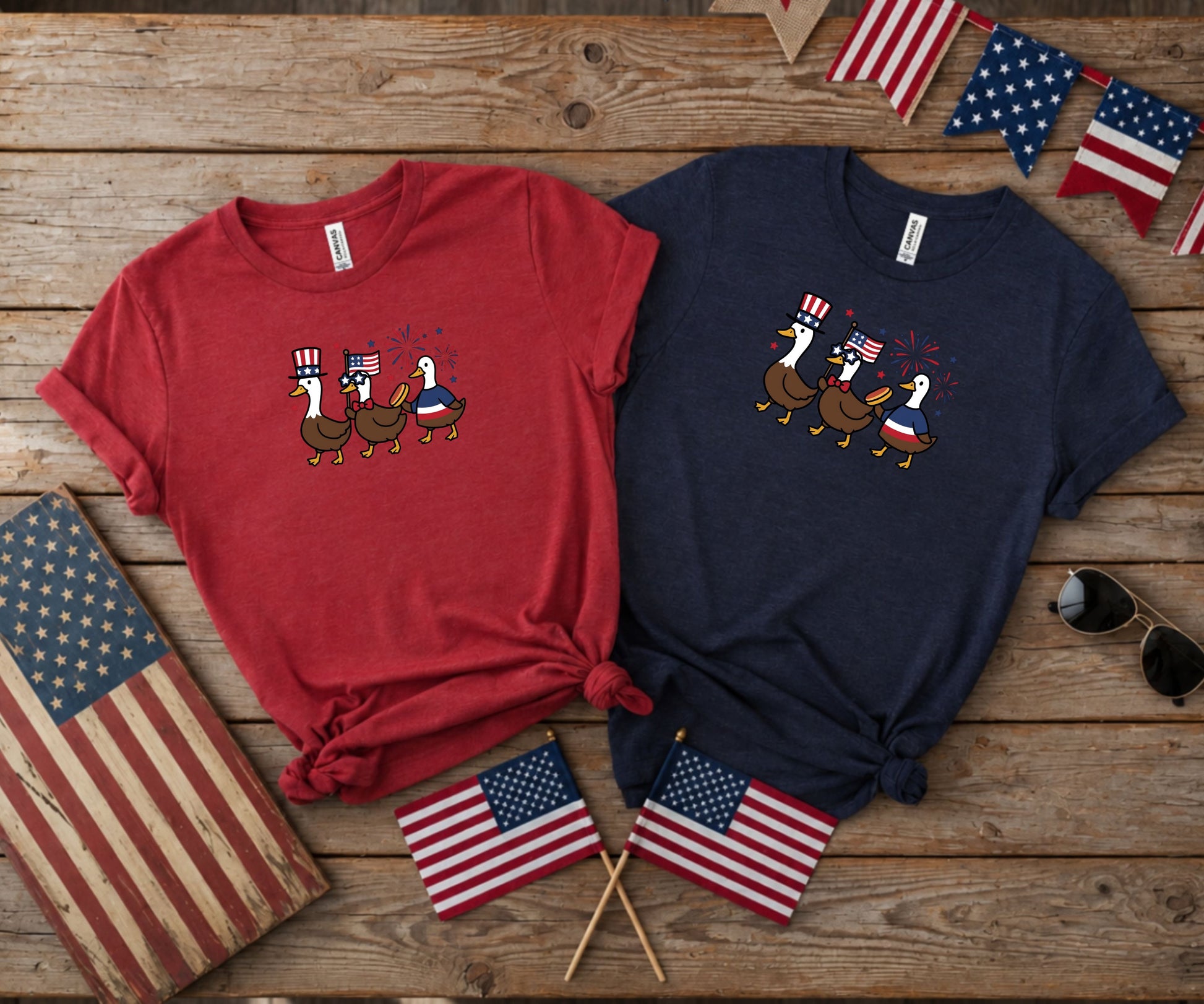 Two t-shirts with patriotic ducks, American flags, and fireworks.