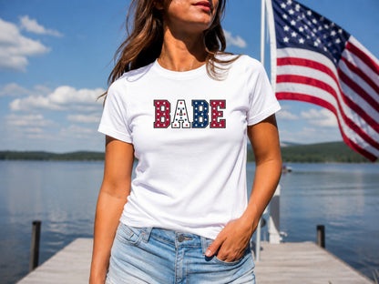 White t-shirt with "BABE" in red, white, and blue stars and stripes.