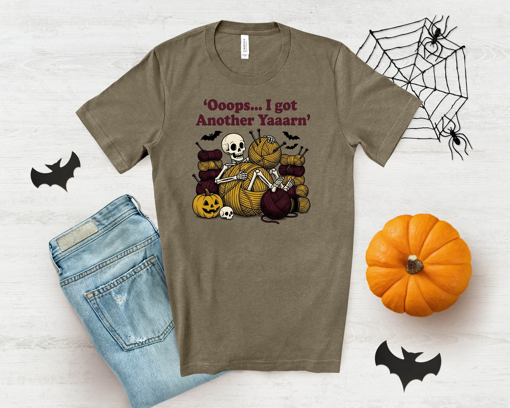 T-shirt with skeleton knitting, pumpkins, bats, and text 'Oooops... I got Another Yaaarn'.