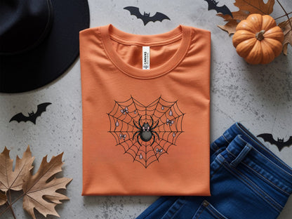 Orange t-shirt with spider web and spider graphic, set for Halloween theme.